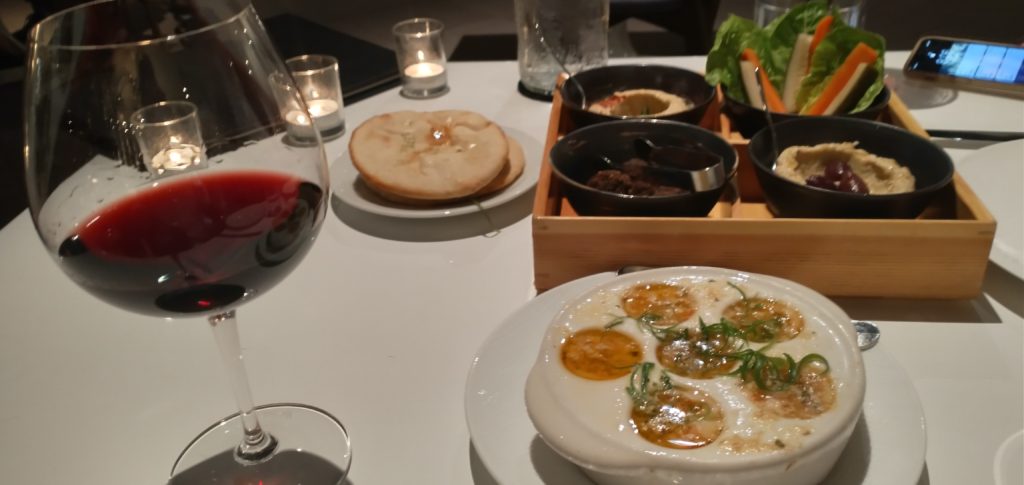 picture of a glass of rhone blend, bento box, flat bread, and the baked escargot