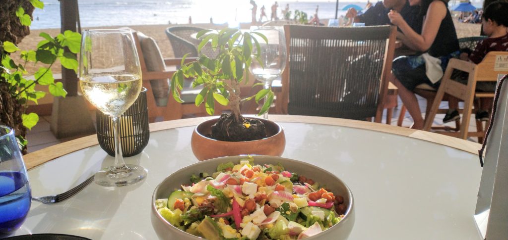 picture of the chopped salad in a bowl by a glass of sauvignon blanc.