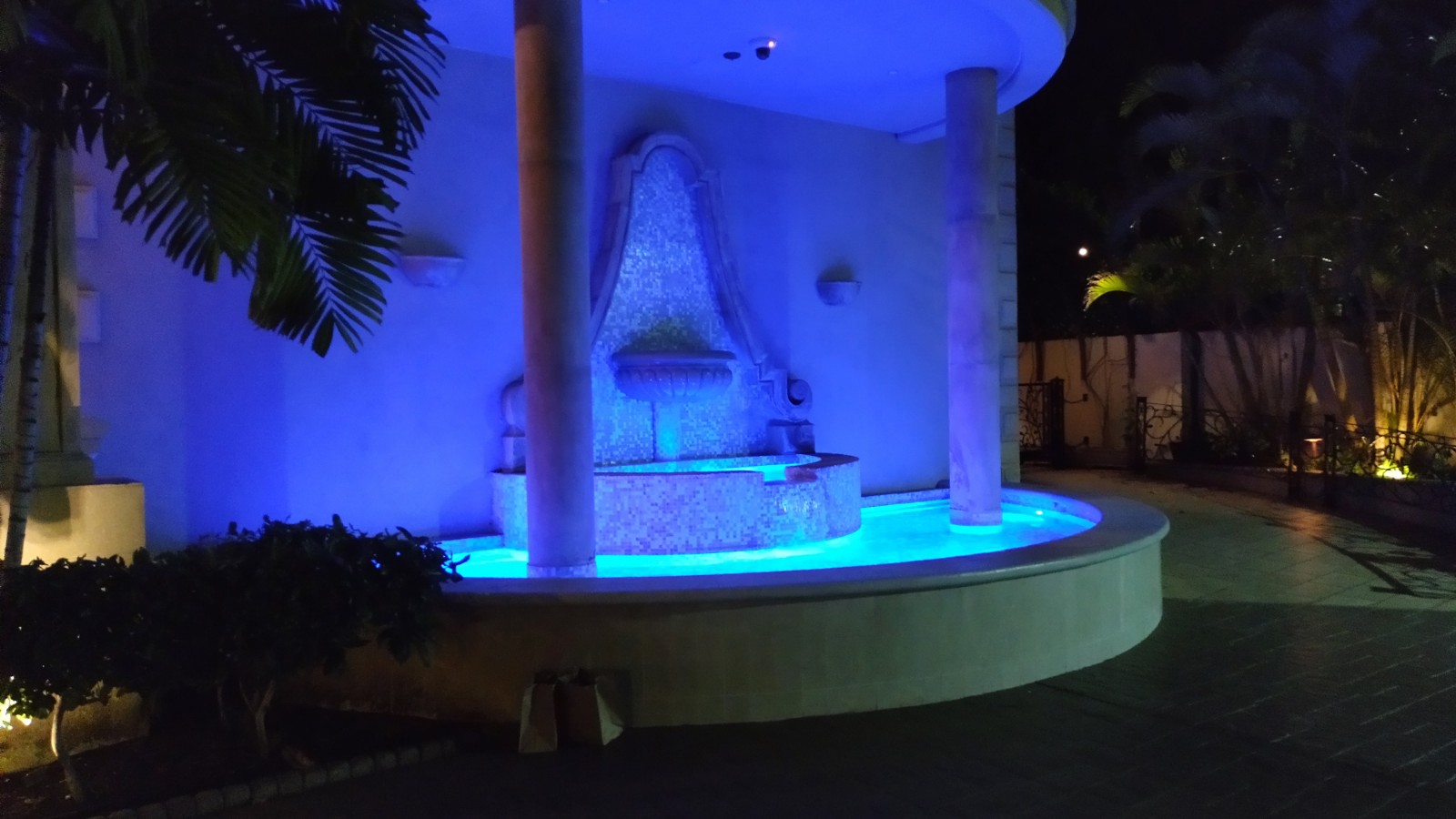 EVENING PICTURE OF THE OUTDOOR WATERFALL BY THE ENTRANCE.