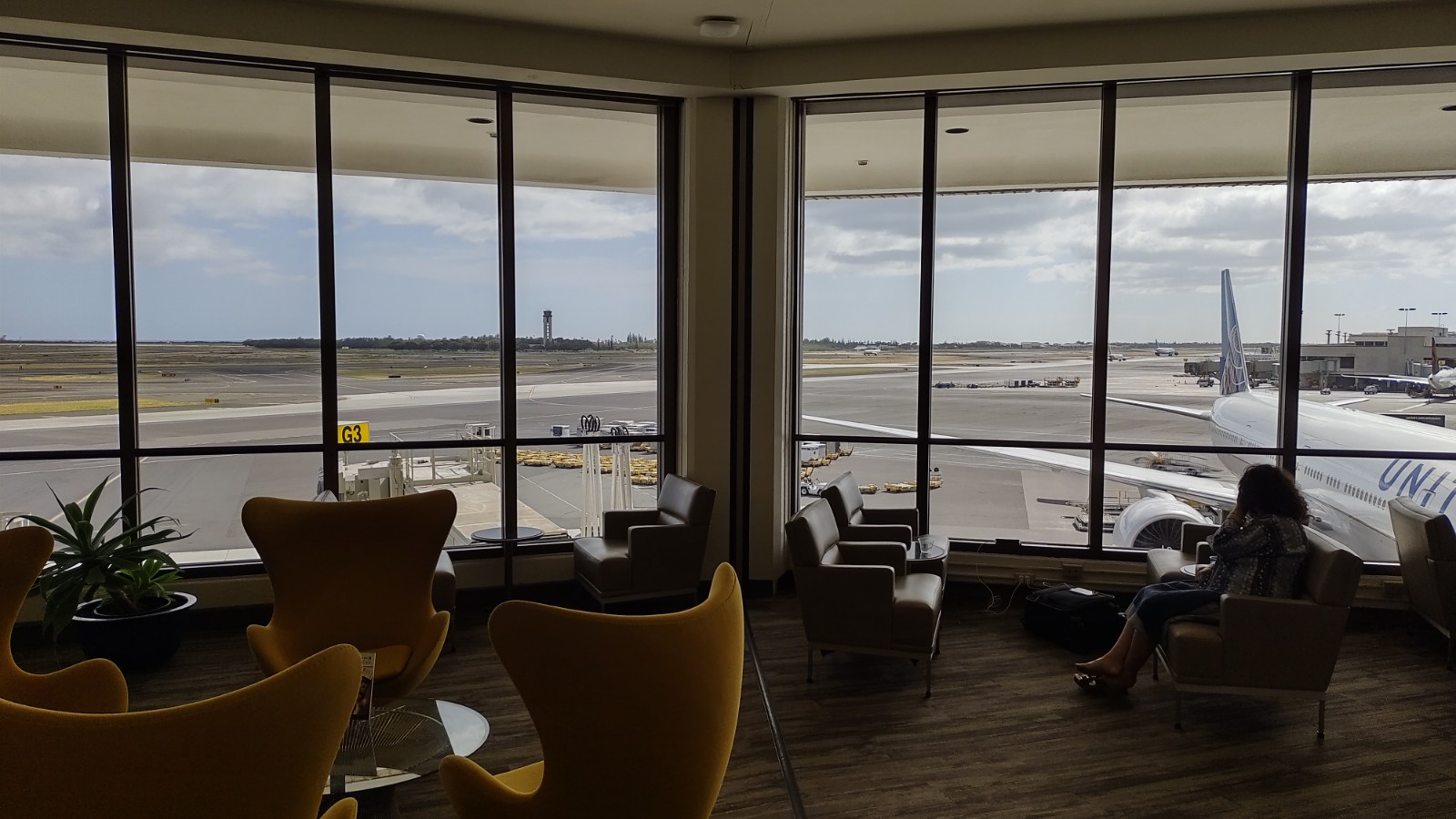 PICTURE OF THE LOUNGE OVERLOOKING AIRCRAFT AT THE GATE BELOW.