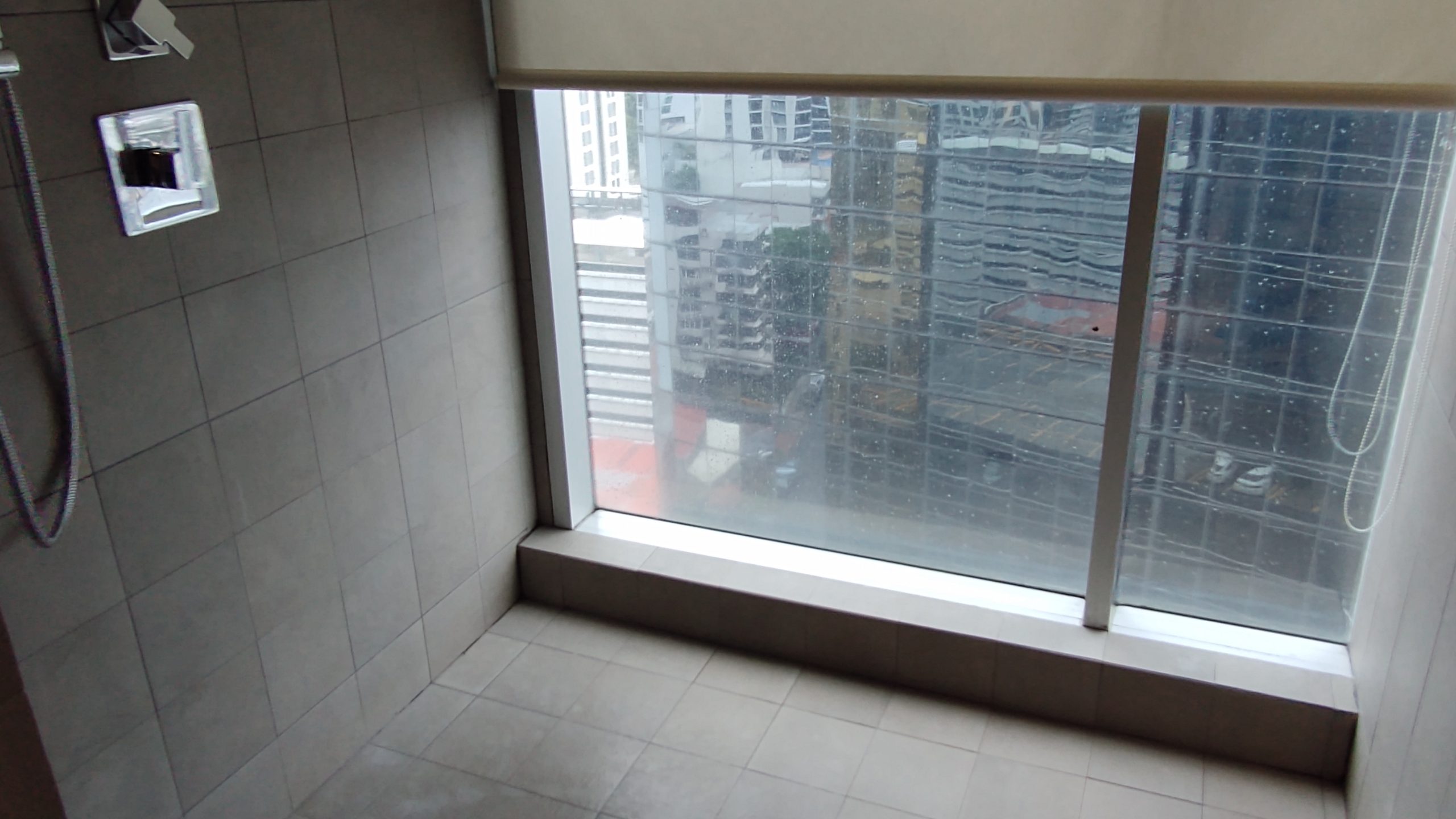 picture of the shower room with window view of the city.