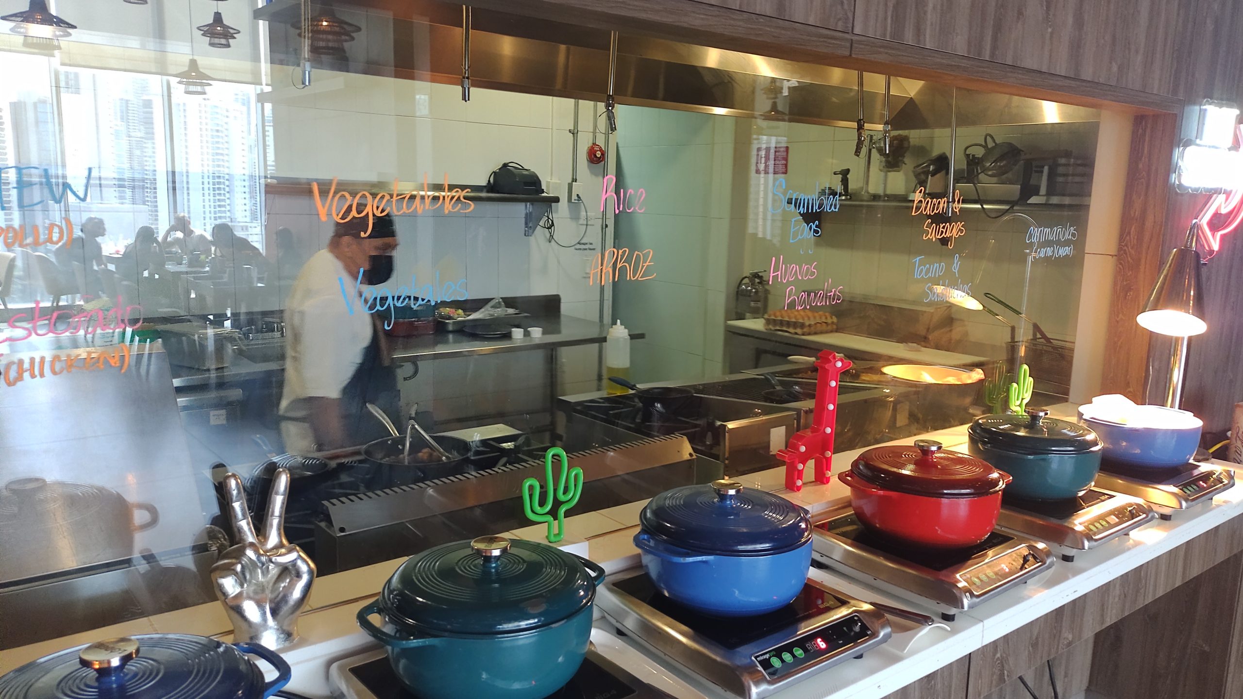 picture of the hot sation  with the chef working in the kitchen behind the glass.