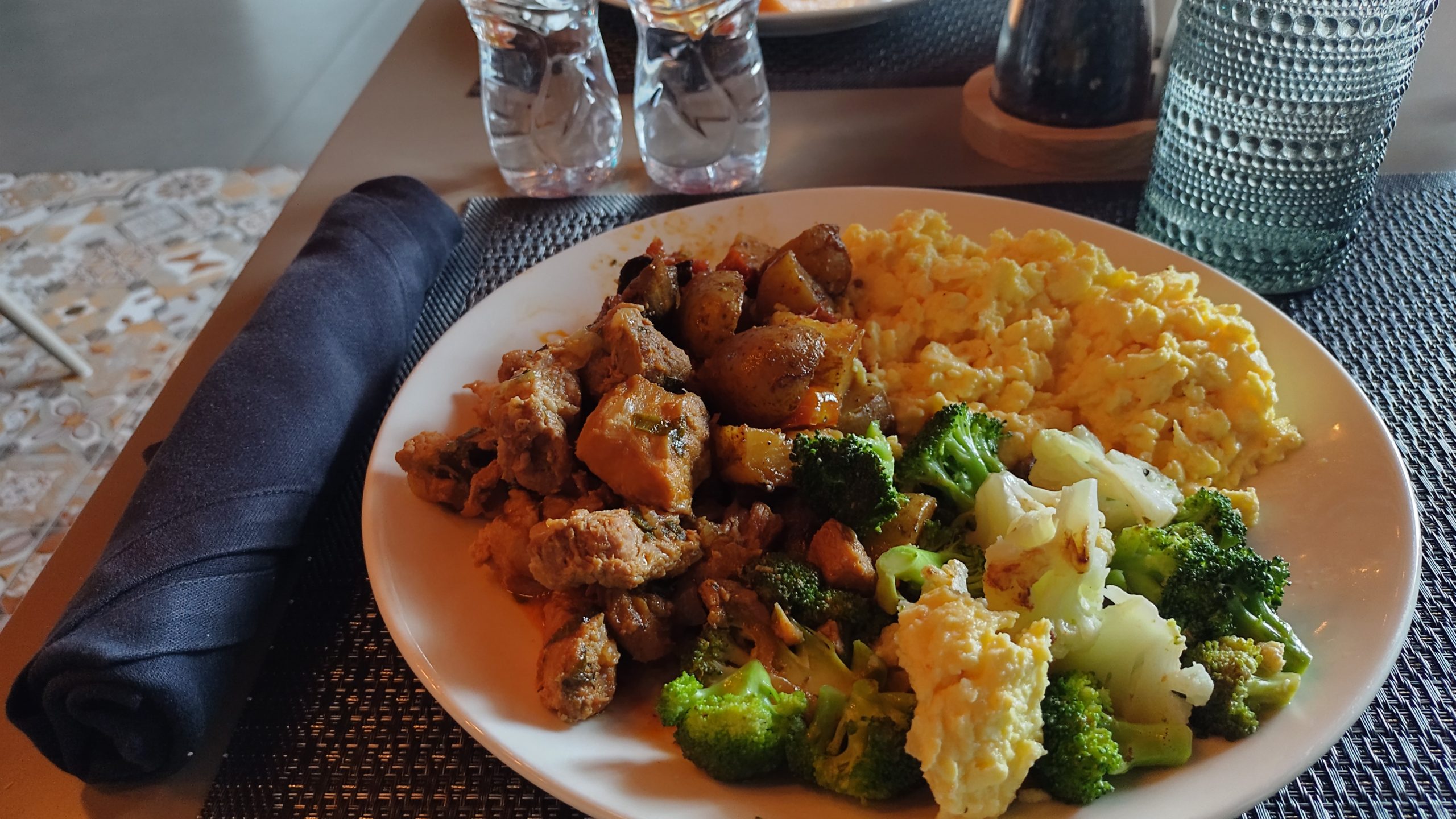 PICTURE OF A PLATE WHITH THE VEGETABLES, CHICKIEN STEW AND SCRAMBLED EGGS.