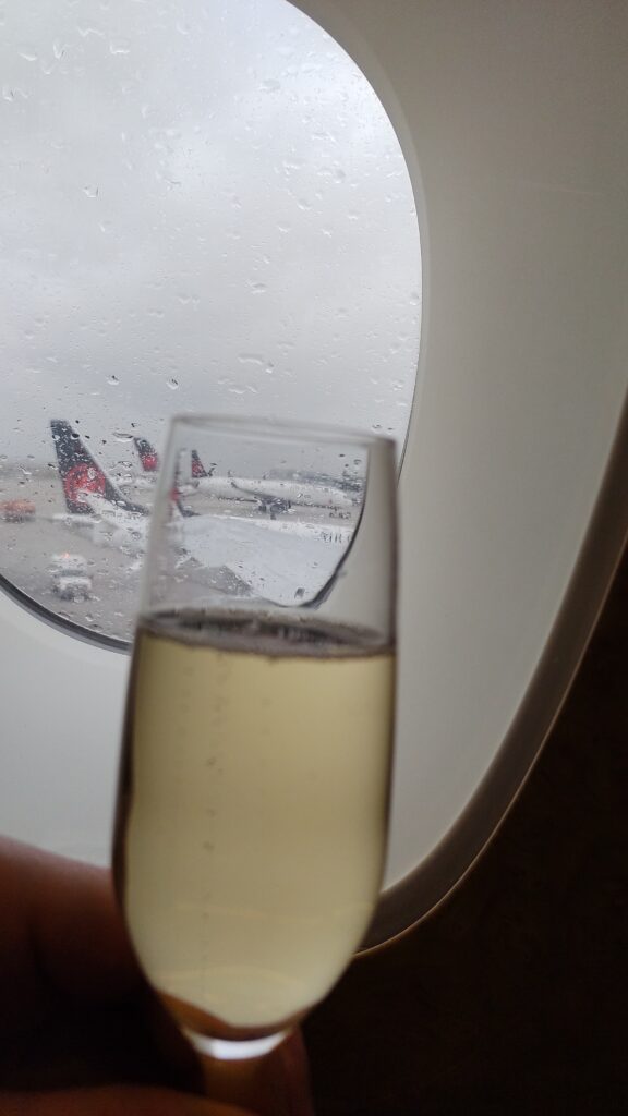 picture of my glass of champagne by the window overlooking the ramp on a rainy cold day in Toronto.