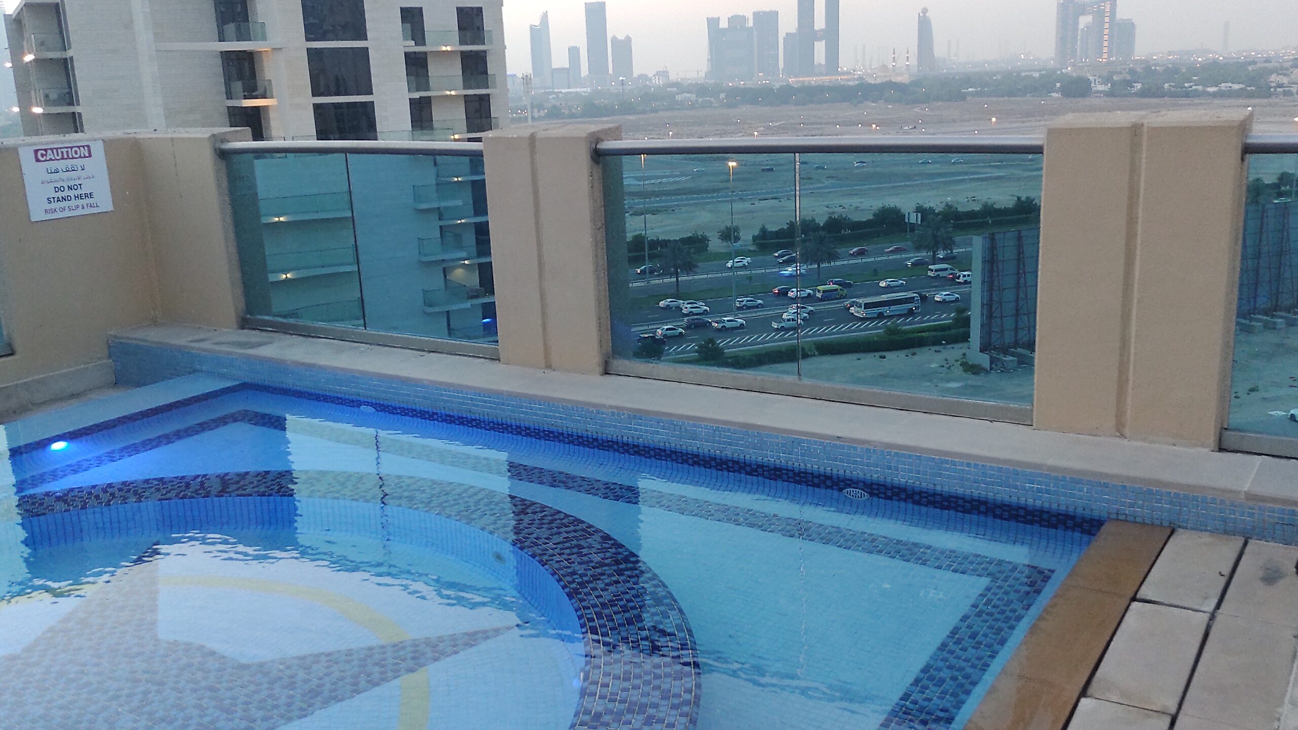 PICTURE OF THE POOL WITH VIEW OF DOWNTOWN ON THE HORIZON.