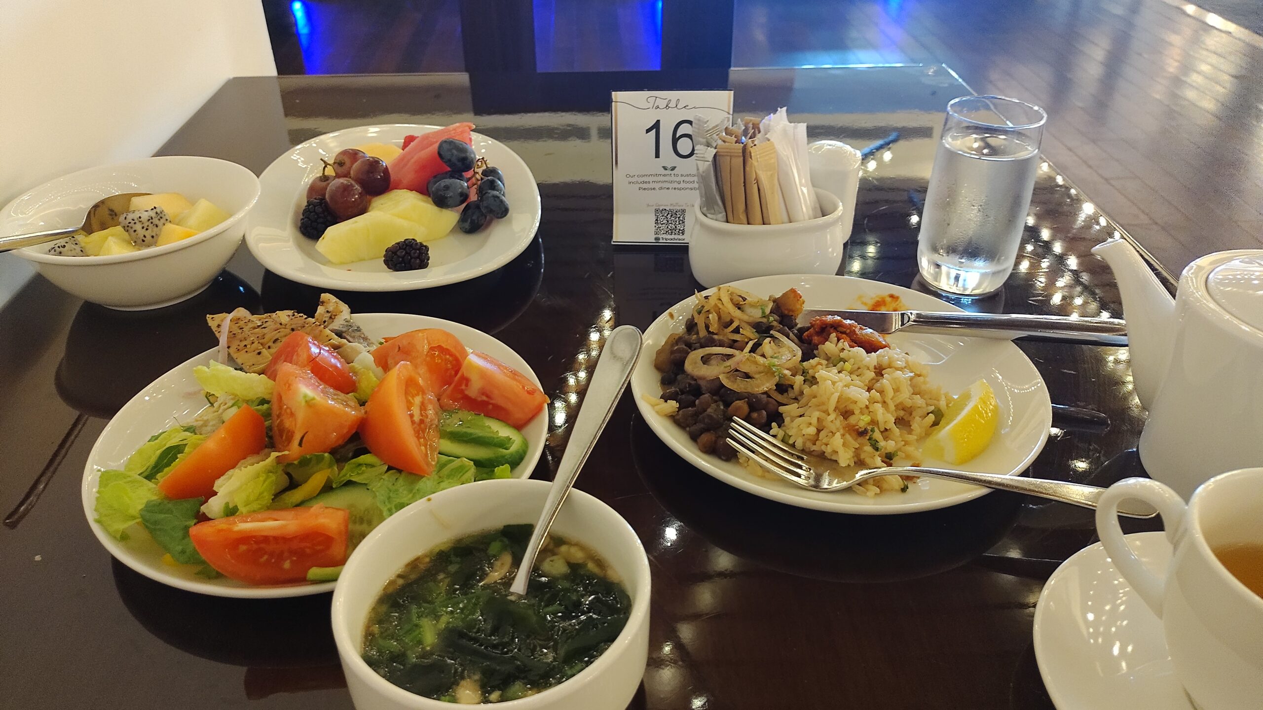 PICTURE OF ONE OF THE TABLES LOADED WITH A VARIETY OF PLATES FROM THE BUFFET.