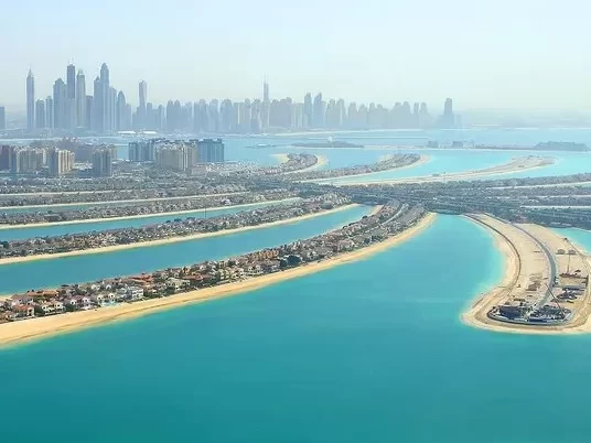 A PICTURE OF THE MAN MADE ISLAND OF PALM JUMEIRAH WITH MANY OF THE COMPLETE RESIDENCES.