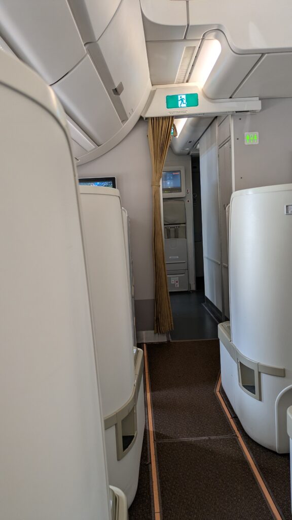 A PICTURE OF THE BUSINESS CLASS AISLE AND CABIN LEADING TO MY SEAT.