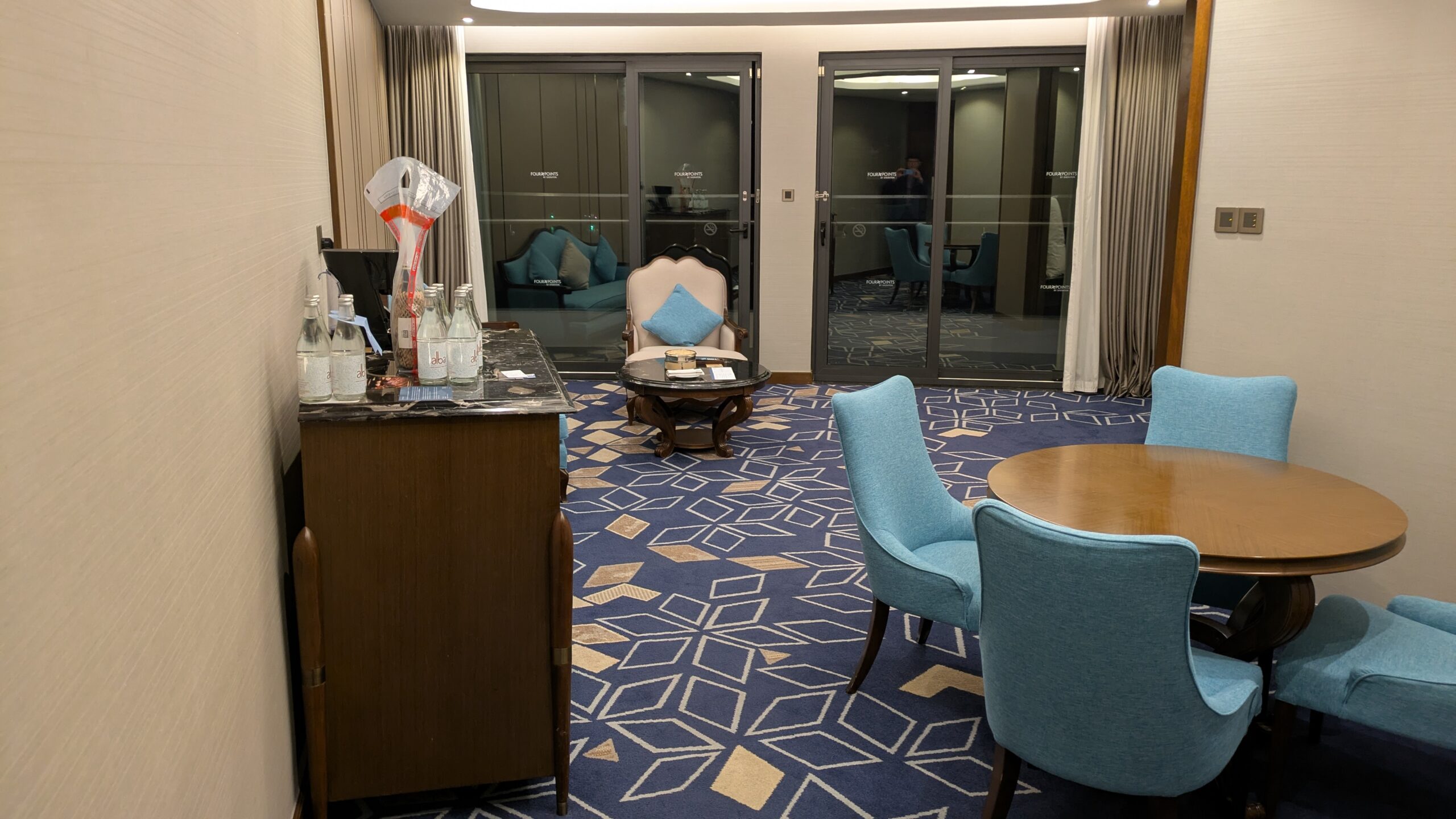 PICTURE OF THE DINING ROOM AND LIVING ROOM LOOKING OUT TO THE BALCONY DOORS.