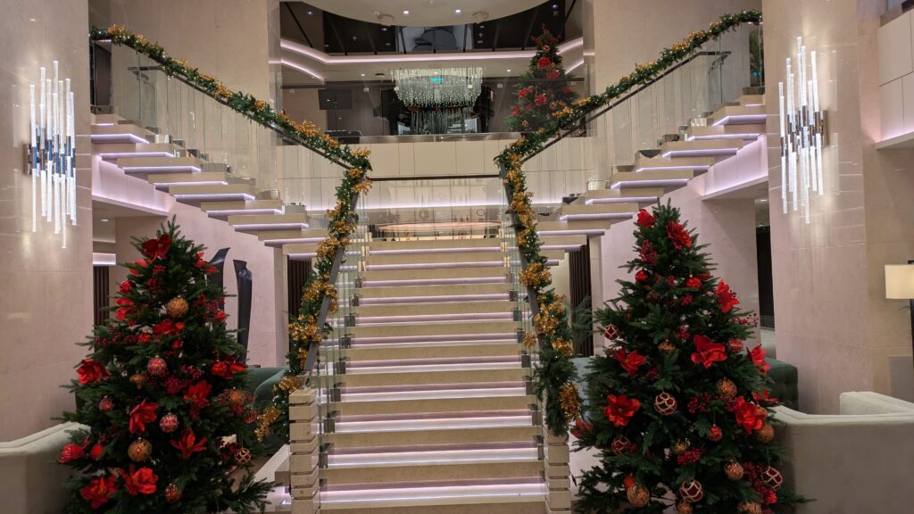 THE MAIN LOUNGE STAIRCASE ALL DECKED OUT IN CHRISTMAS FARE COMPLETE WITH CHRISTMAS TREES.